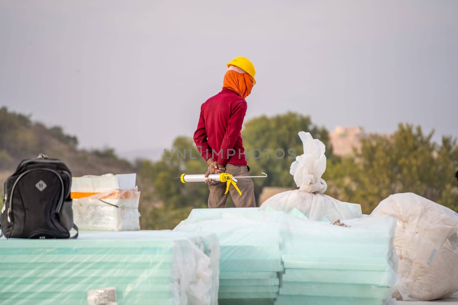labourer with face covered to protect from the heat looking down showing the real estate industry in India