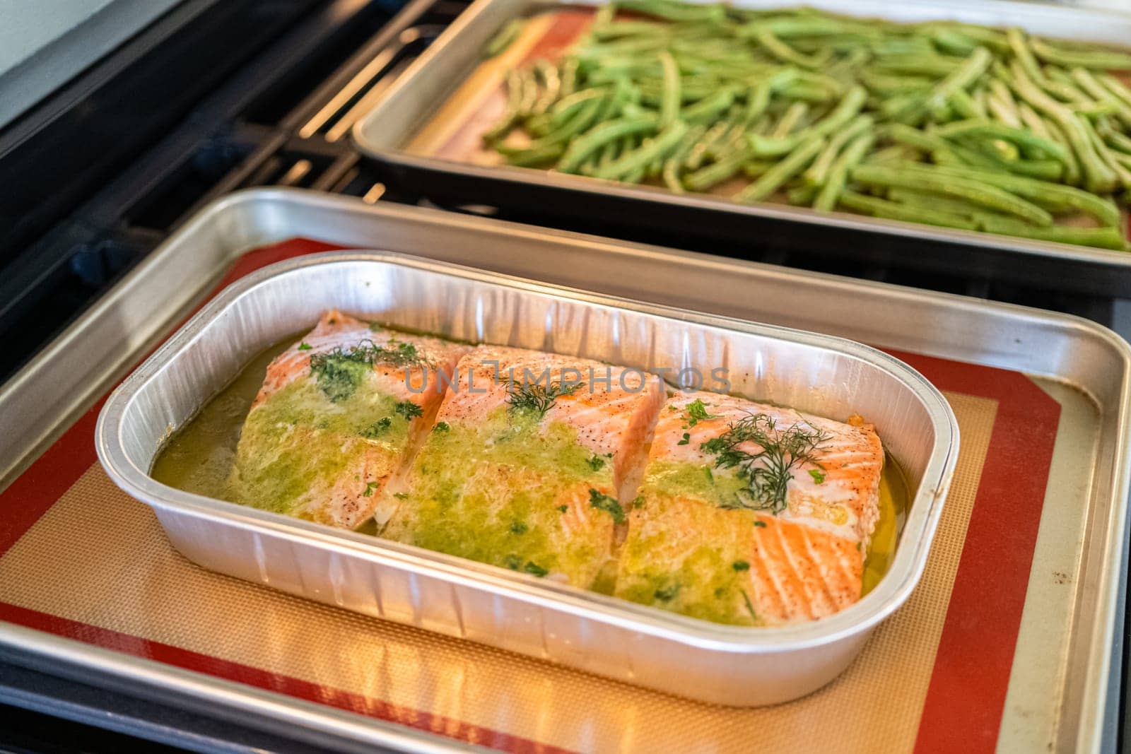 Discover the mouthwatering journey of salmon as it's cooked to perfection in an oven, nestled in a foil tray, adorned with rich butter and tantalizing spices.
