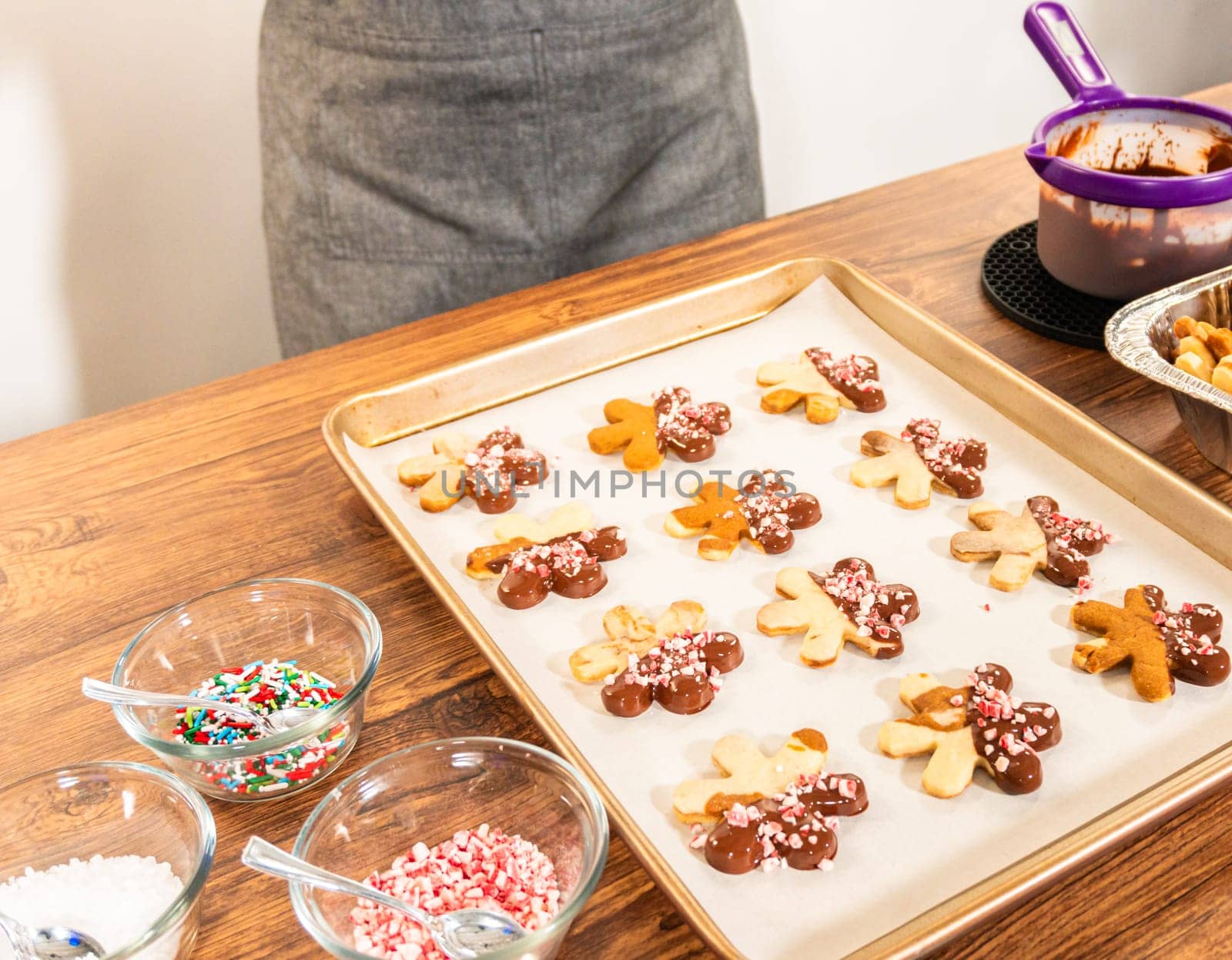 Preparing star-shaped cookies, half-dipped in chocolate, accented with peppermint chocolate chips for the holidays.
