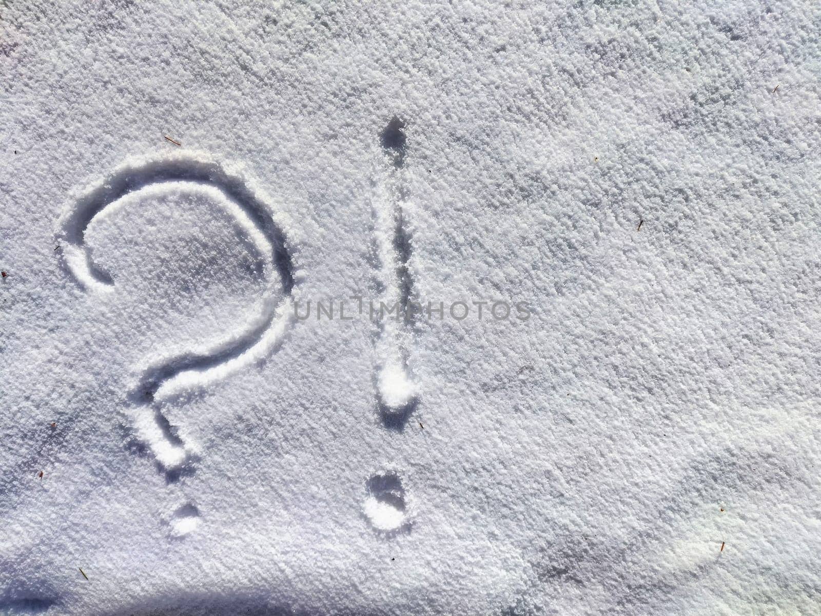 A large question mark is etched into the fresh snow, creating a stark contrast against the white surface on a serene winter morning.