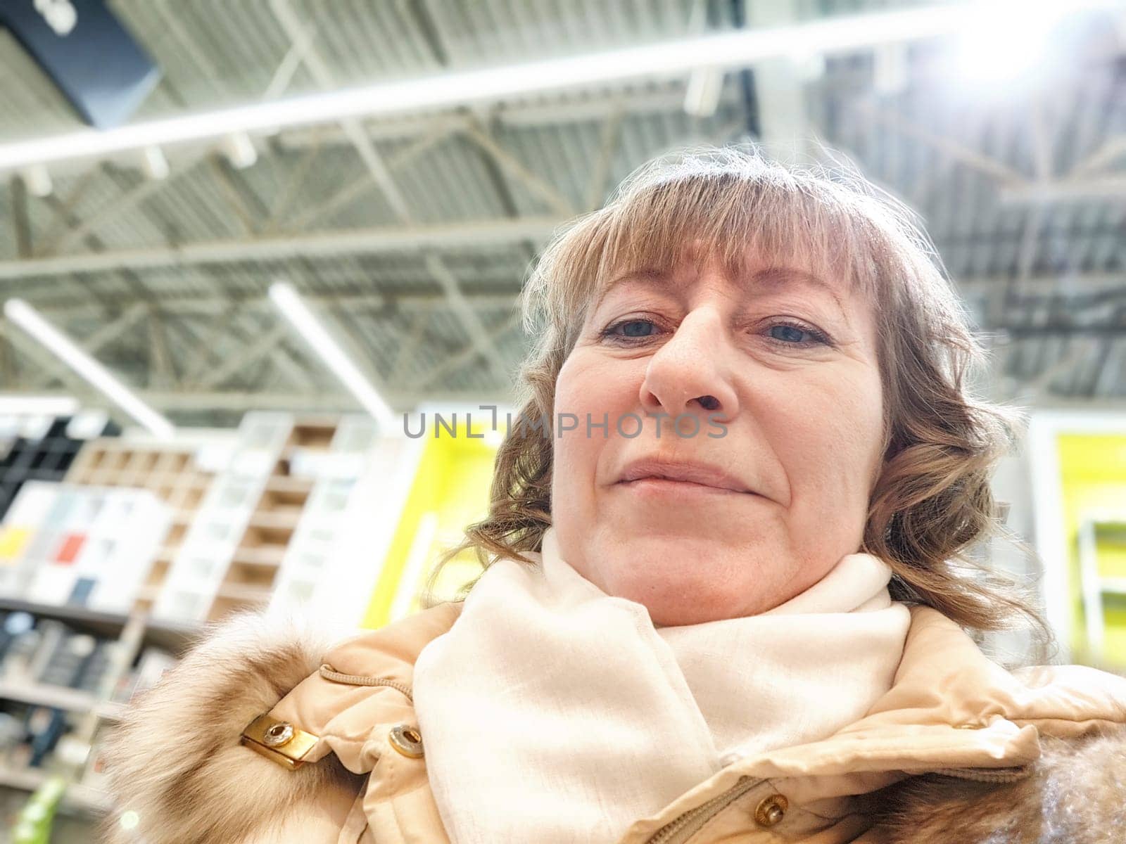 Middle-Aged Woman Shopping at a Warehouse Store. Woman browsing in large retail store aisle