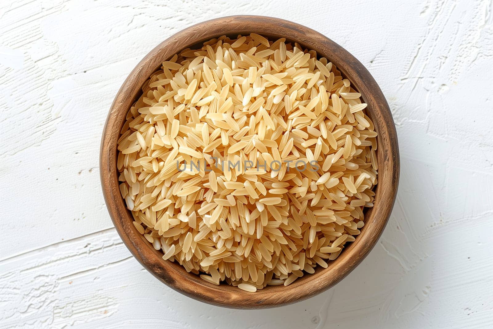 A wooden bowl filled with rice is sitting on top of a white table.