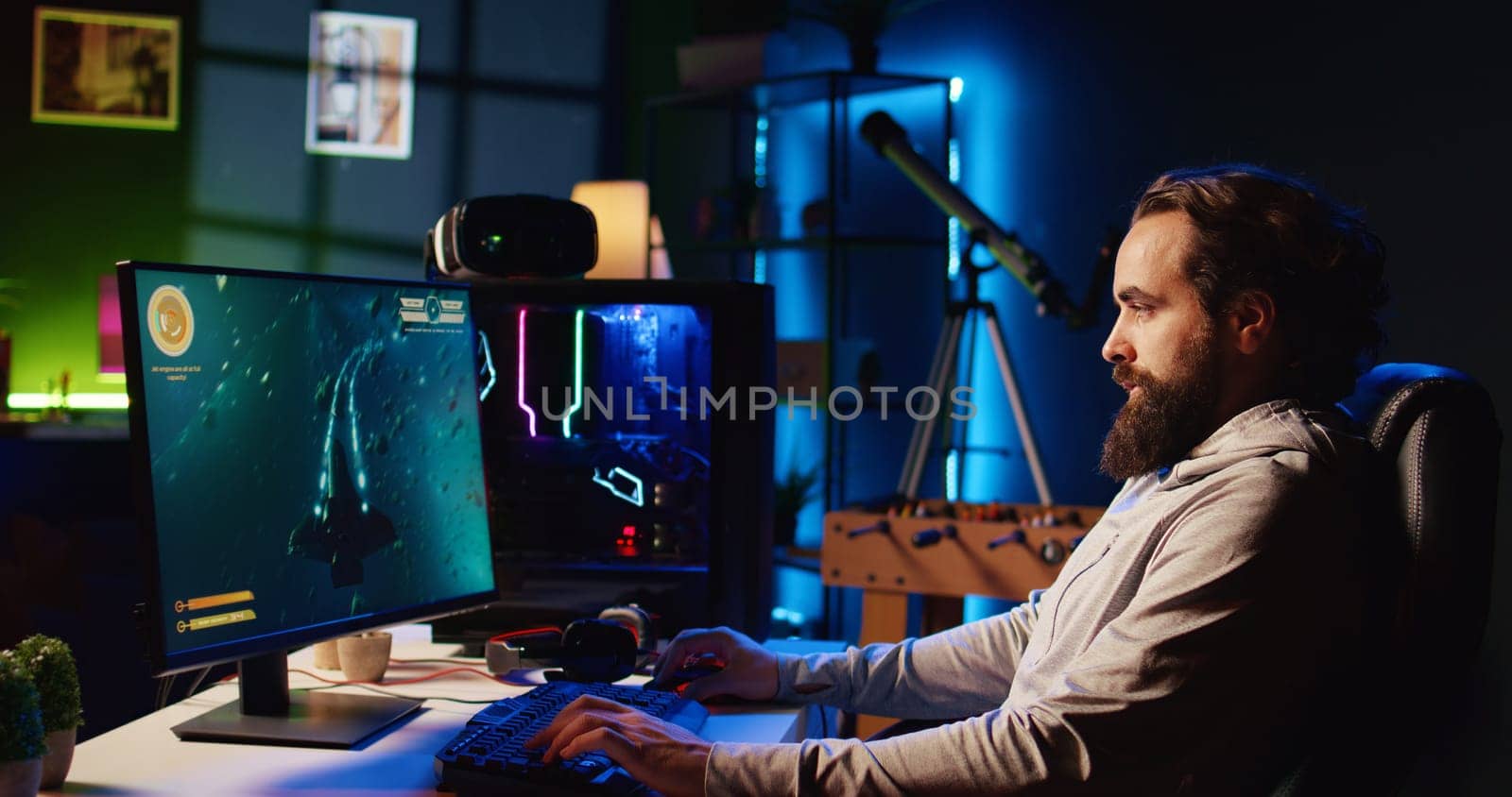 Man in RGB lit studio streaming multiplayer game, chatting with audience while defeating enemies, zoom out shot. Pro gamer using professional equipment to broadcast videogame gameplay to fans