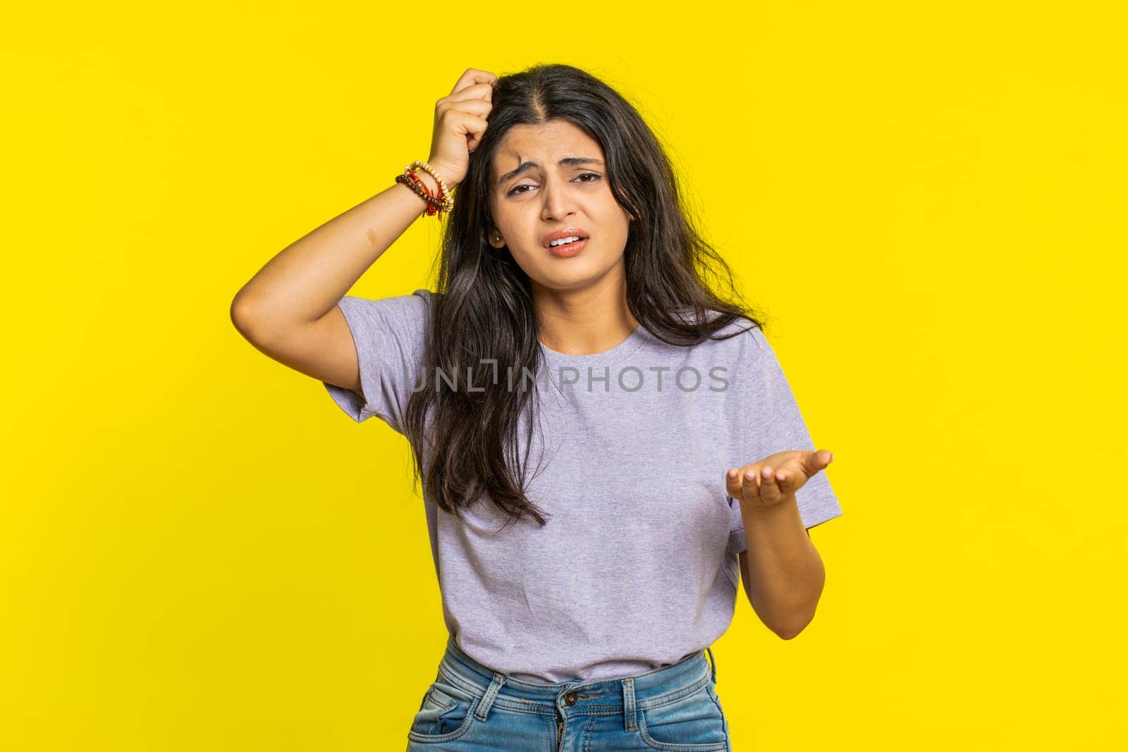 Sad young Indian woman feeling hopelessness loneliness, nervous breakdown loses becoming surprised by lottery results bad fortune loss unlucky news. Attractive Hindu girl isolated on yellow background