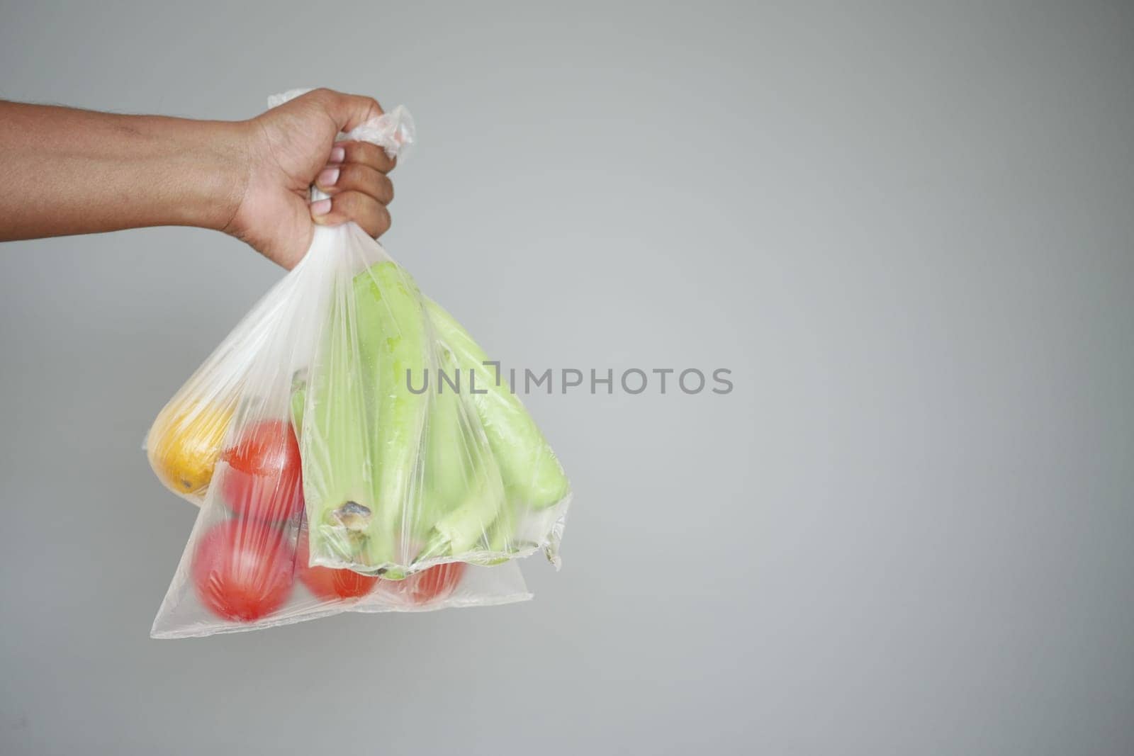 Hand Carrying Fresh Vegetables in Clear Plastic Bag, Healthy Eating and Zero Waste Concept,