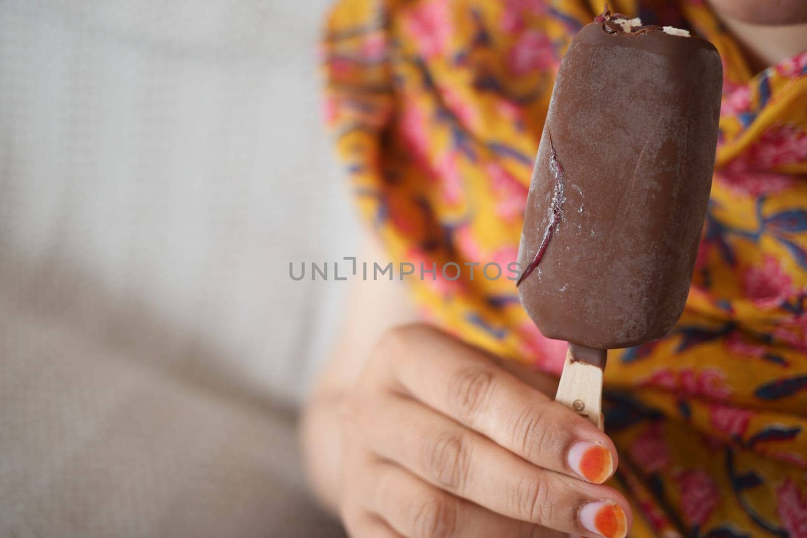 young women eating chocolate flavor ice cream .