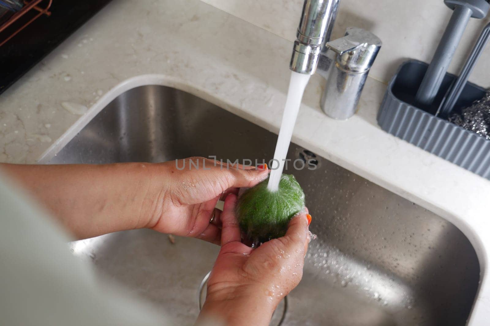 hand washing avocado with water sprinkling.