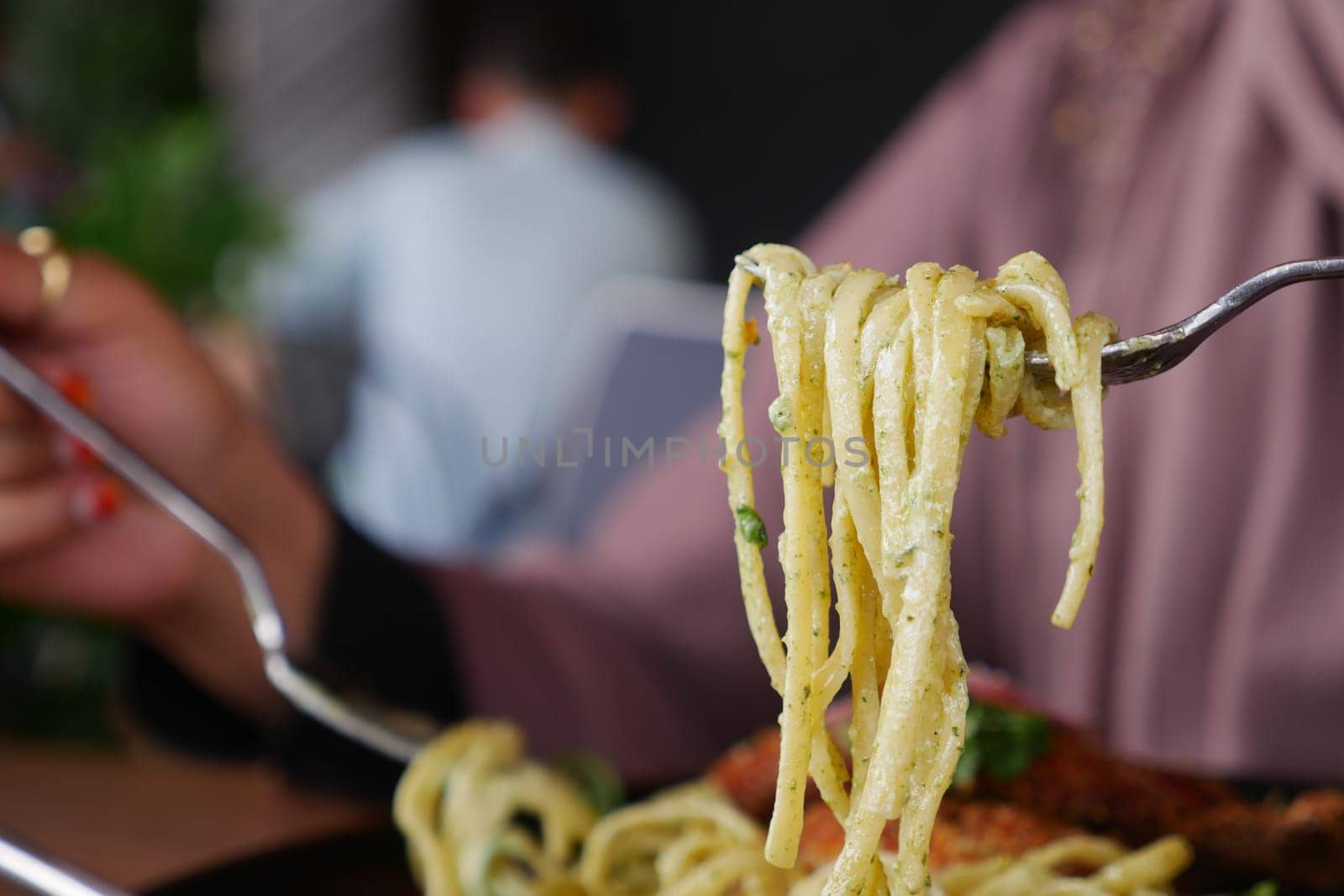 CloseUp of a Fork with Spaghetti in a Charming Italian Restaurant Setting.