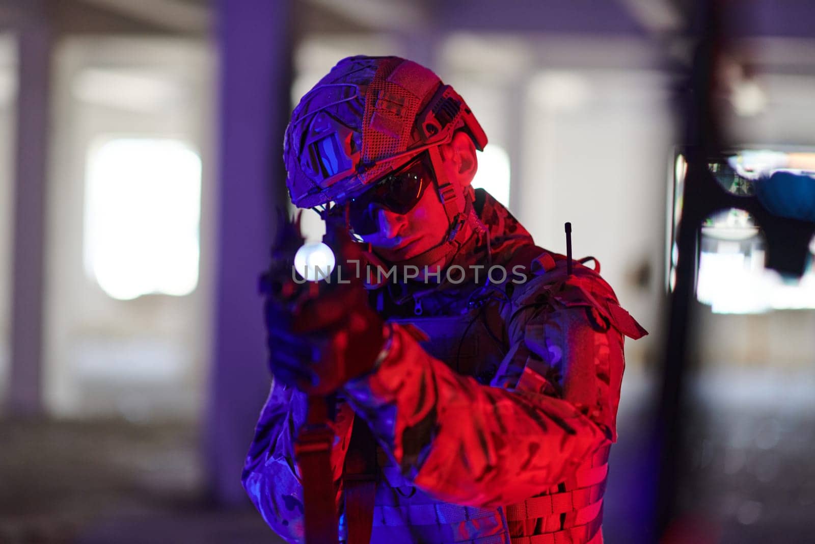 A professional soldier undertakes a perilous mission in an abandoned building illuminated by neon blue and purple lights.