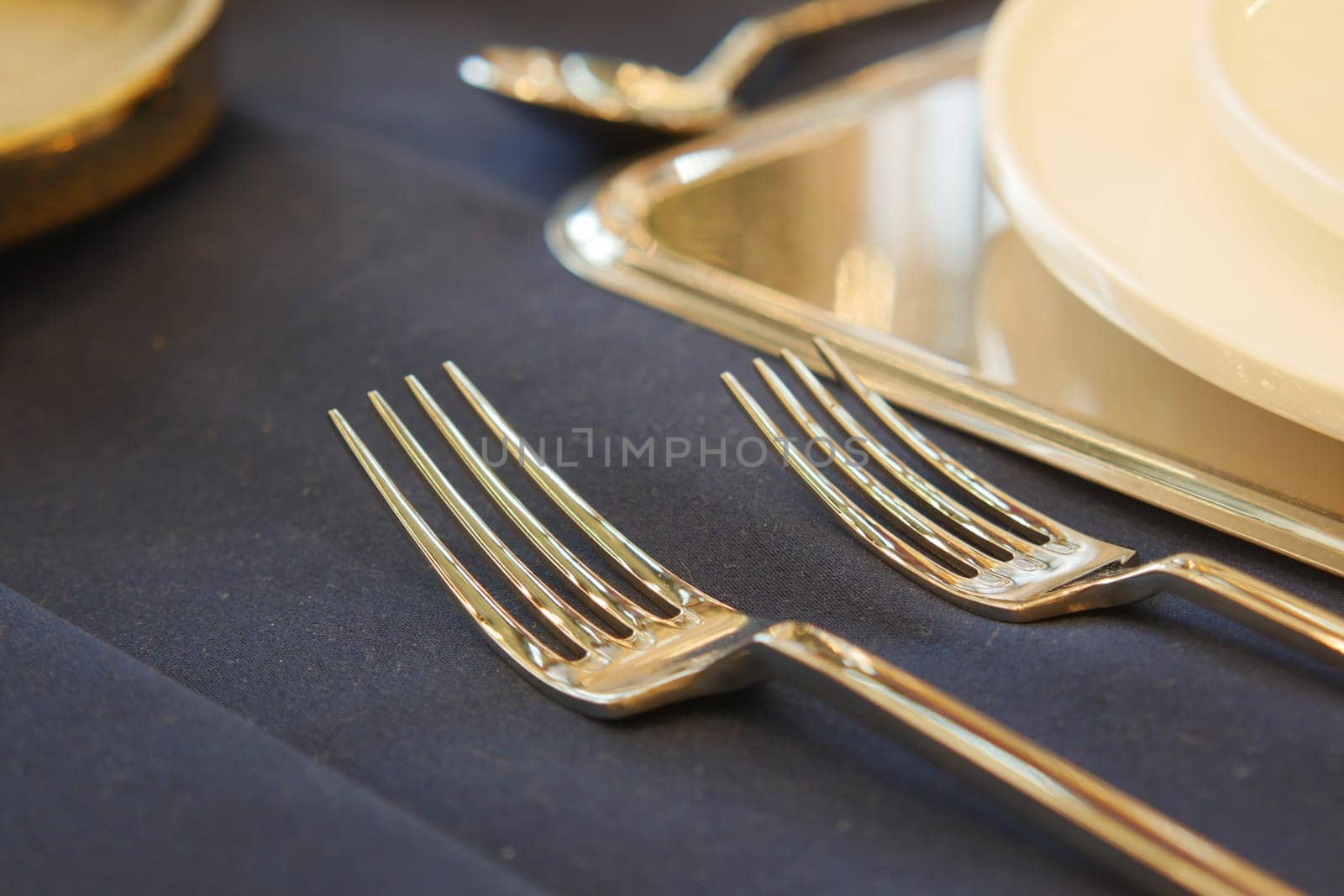 This is a detailed closeup of elegant, shiny silver spoons reflecting light patterns on a wooden surface