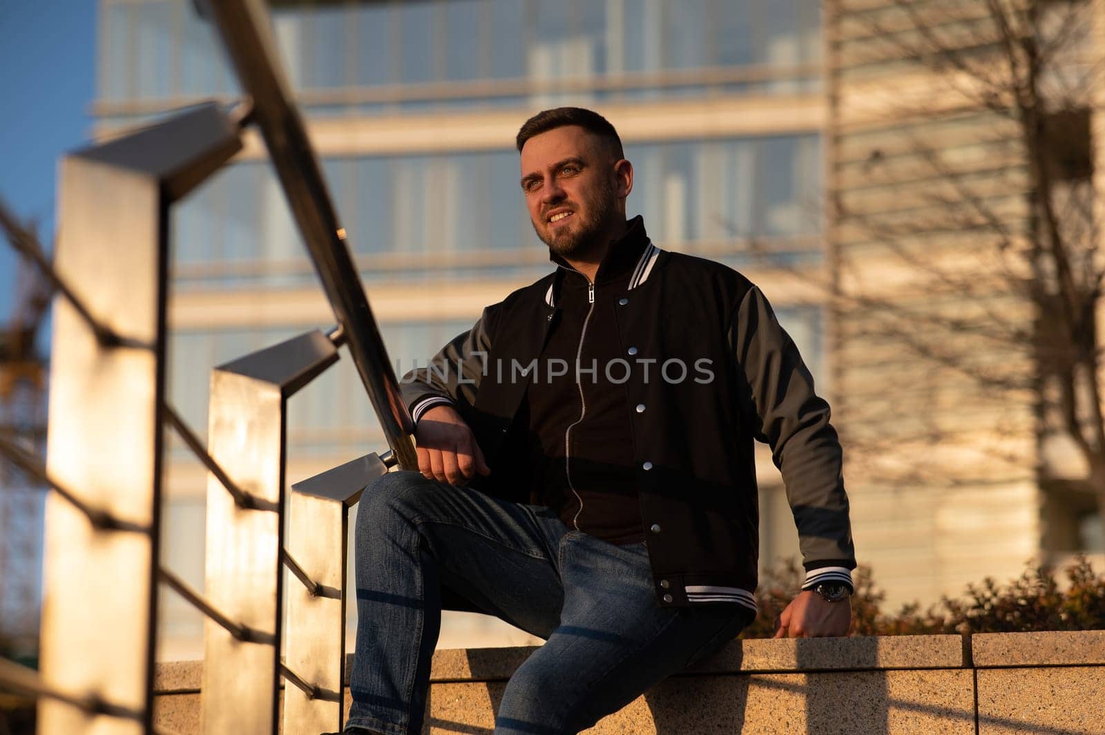 Portrait of a smiling bearded man outdoors at sunset