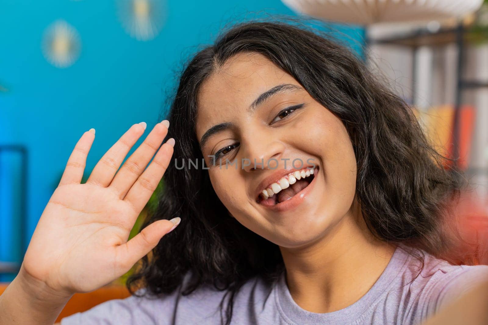 POV view of Indian young woman blogger taking selfie on smartphone communicating video call online with subscribers recording stories for social media. Happy Arabian girl holds mobile phone with hand