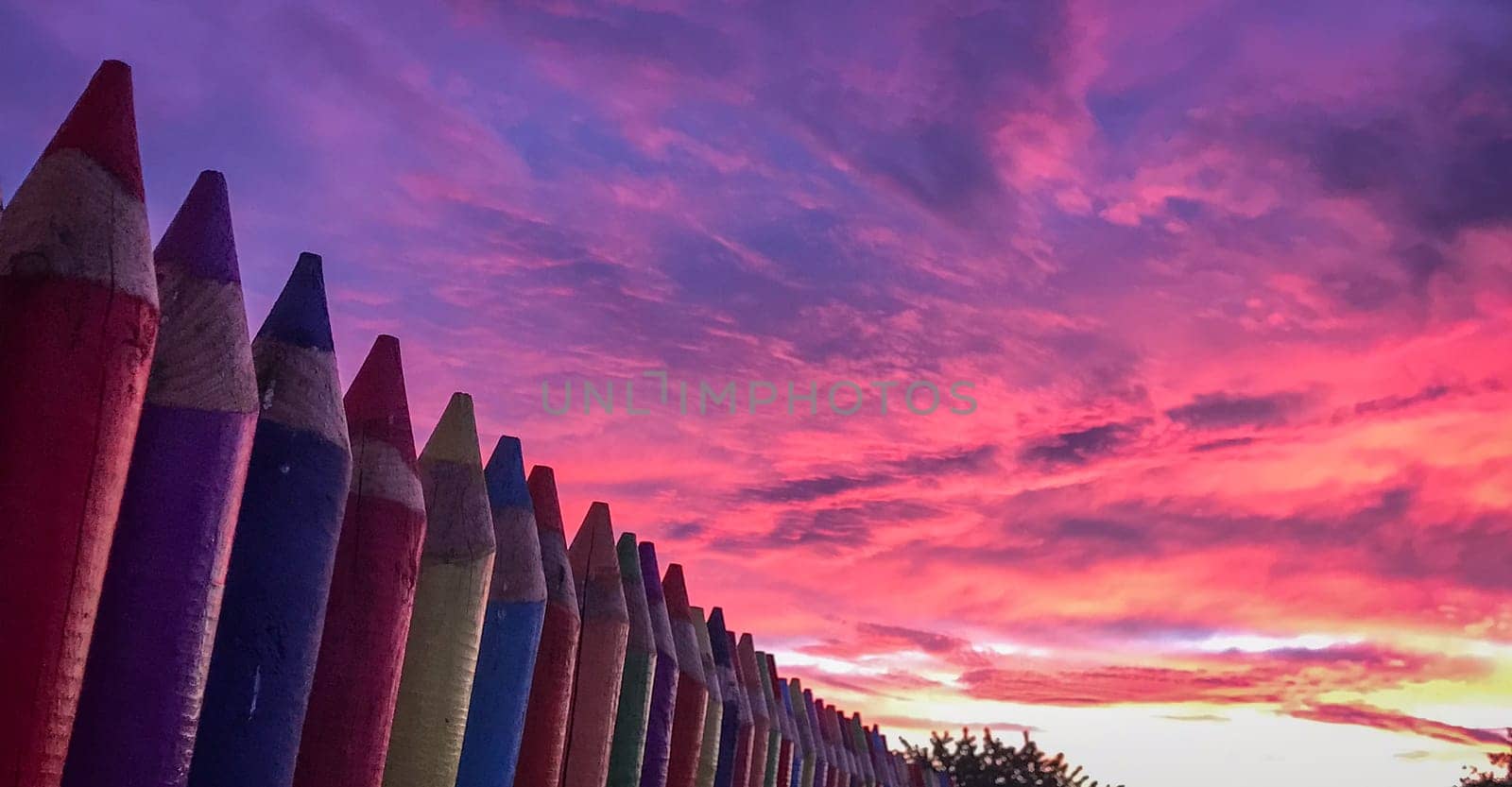 A beautiful image of a school wall in coloured pencils against a blushing evening sky, High quality photo