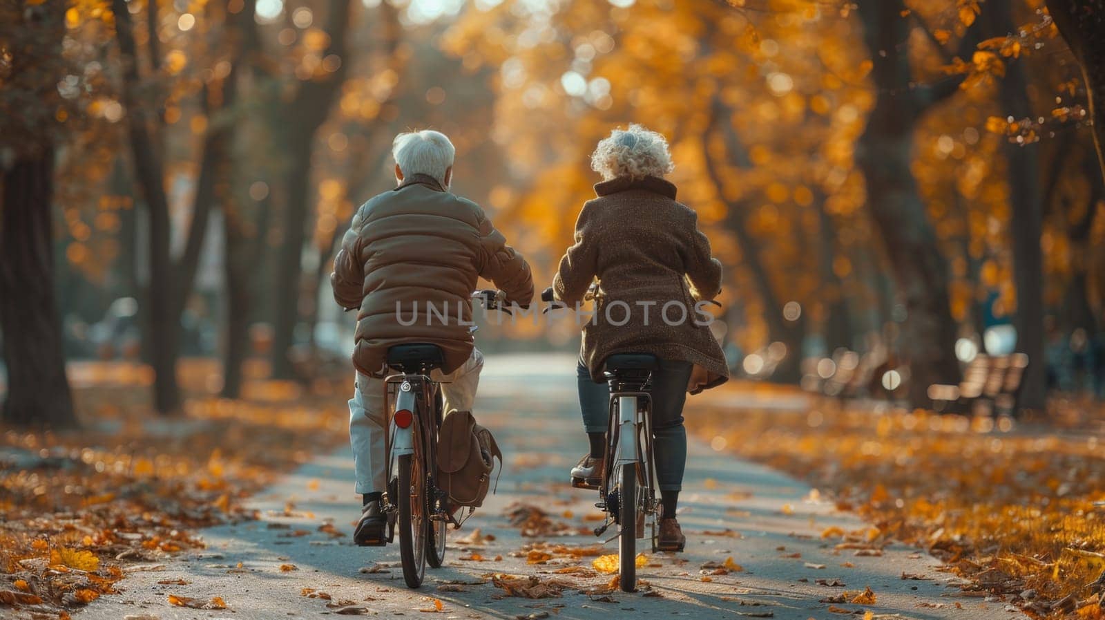 Two fun-loving seniors bike together in the fall to stay fit and healthy. Active elderly couple on bicycles.