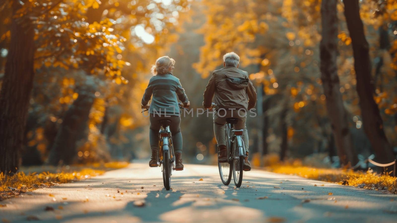 Two fun-loving seniors bike together in the fall to stay fit and healthy. Active elderly couple on bicycles.