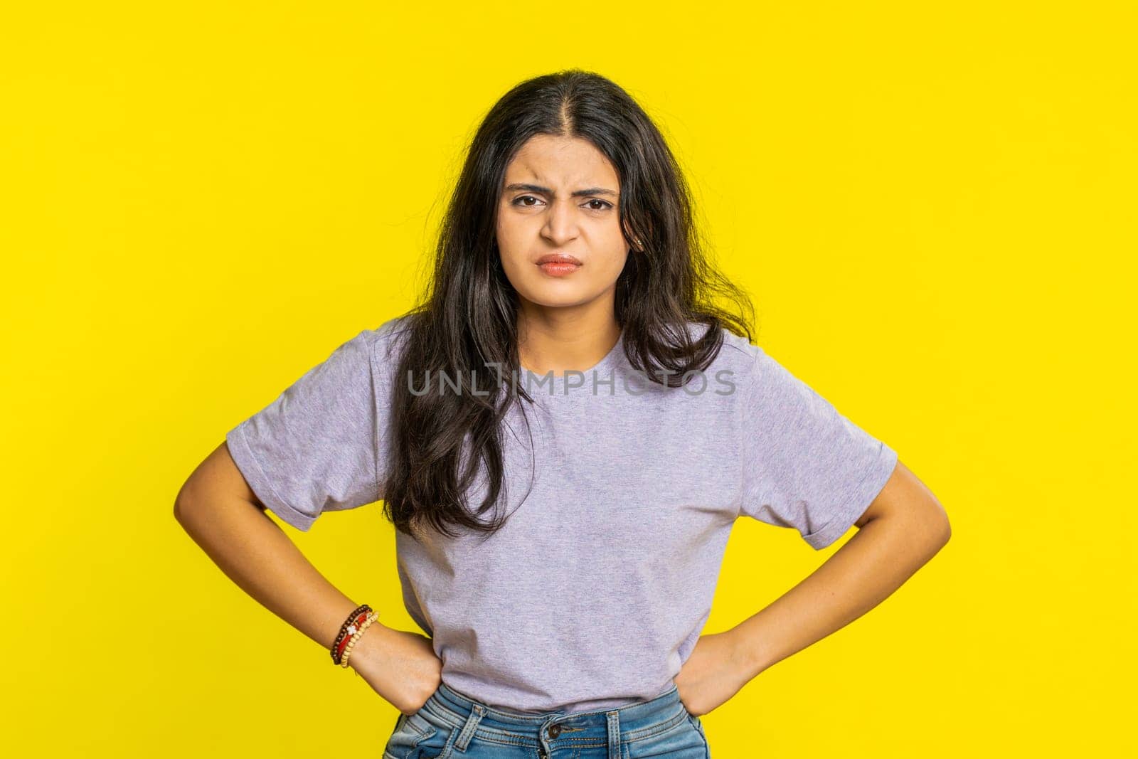 Irritated angry Indian woman screams from stress tension problems feels horror hopelessness fear surprise shock expresses rage nervous, quarrel. Arabian young girl isolated on yellow studio background