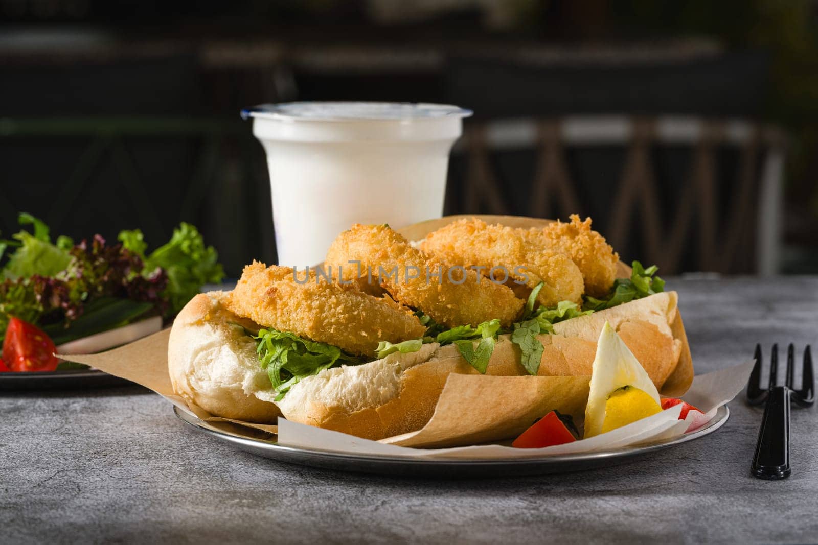 Deep fried squid in bread with greens on the side. Squid sandwich