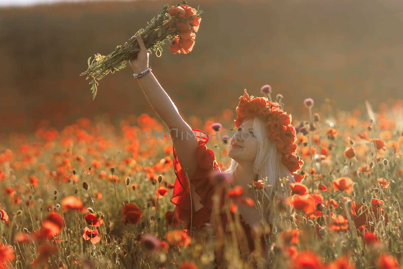 A woman is standing in a field of red flowers, holding a bouquet of flowers in her hand. The scene is serene and peaceful, with the woman surrounded by the beauty of nature