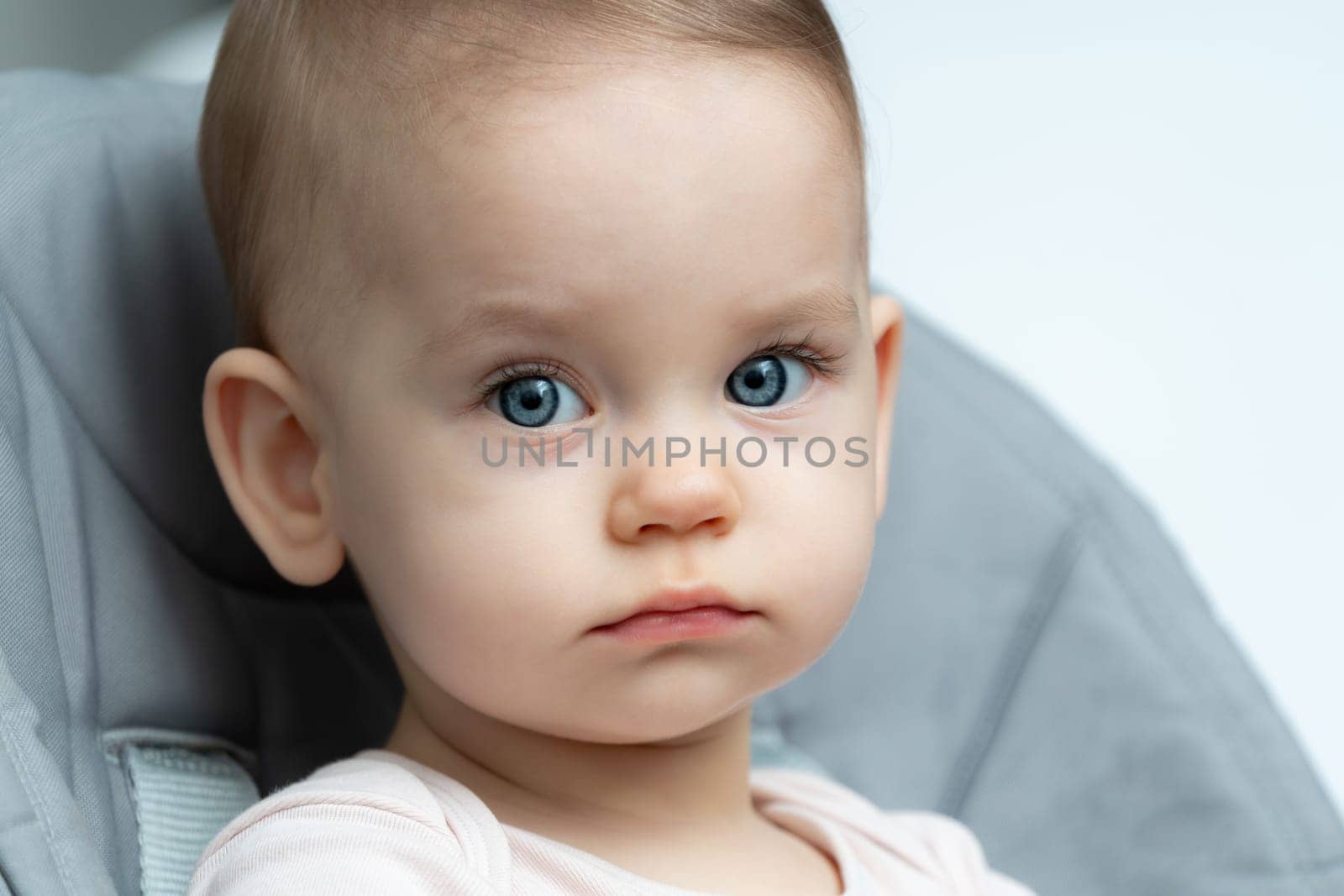 Close-up of an infant baby gazing at the camera with wide-eyed wonder
