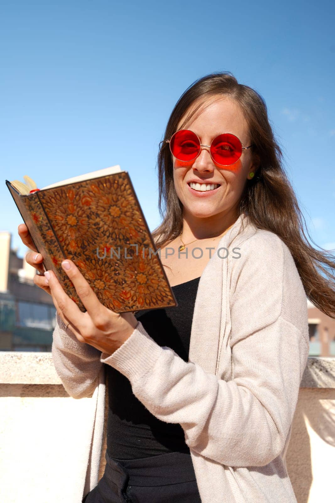 Vertical portrait individual Happy young woman reading a book outdoors by mariaphoto3