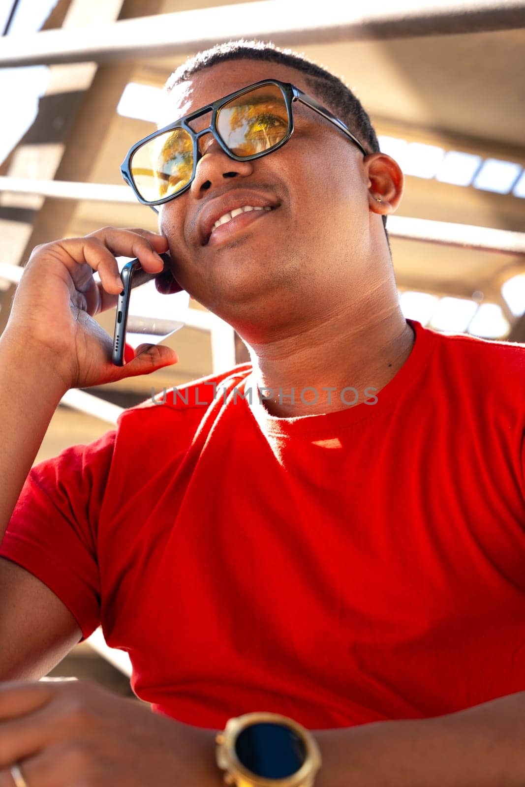 Vertical portrait black man talking on cell Phone smiling by mariaphoto3