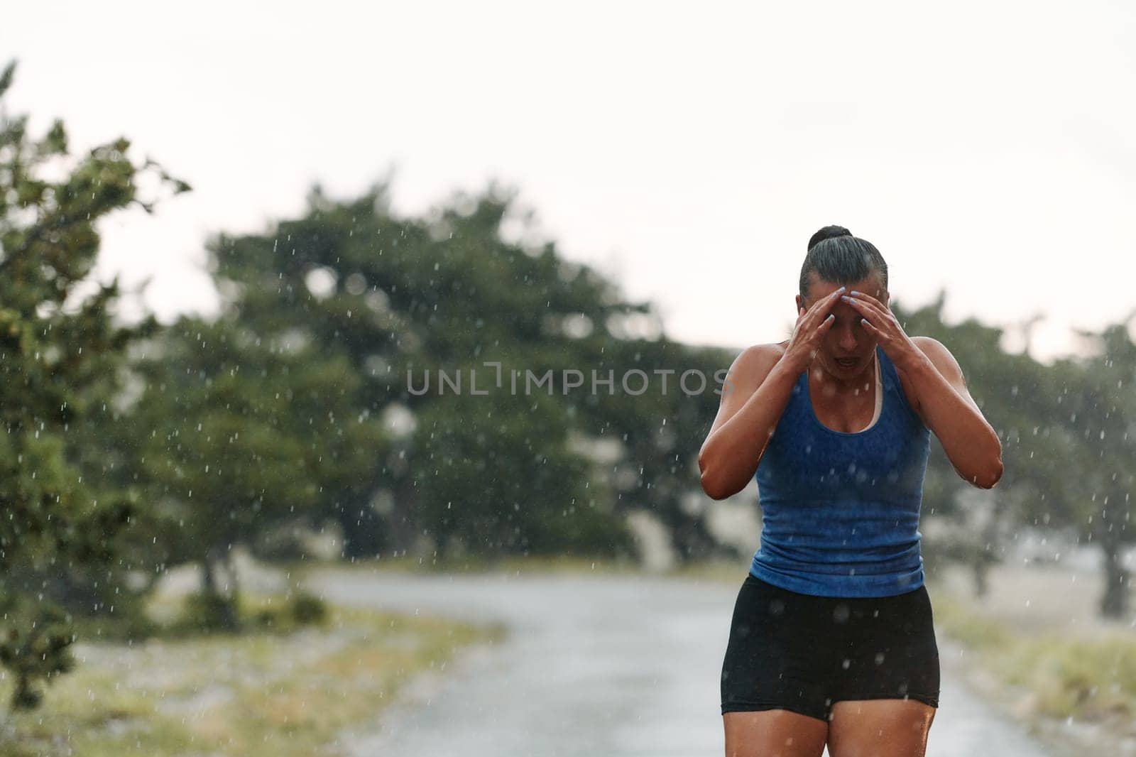 Rain or shine, a dedicated woman powers through her training run, her eyes set on the finish line.