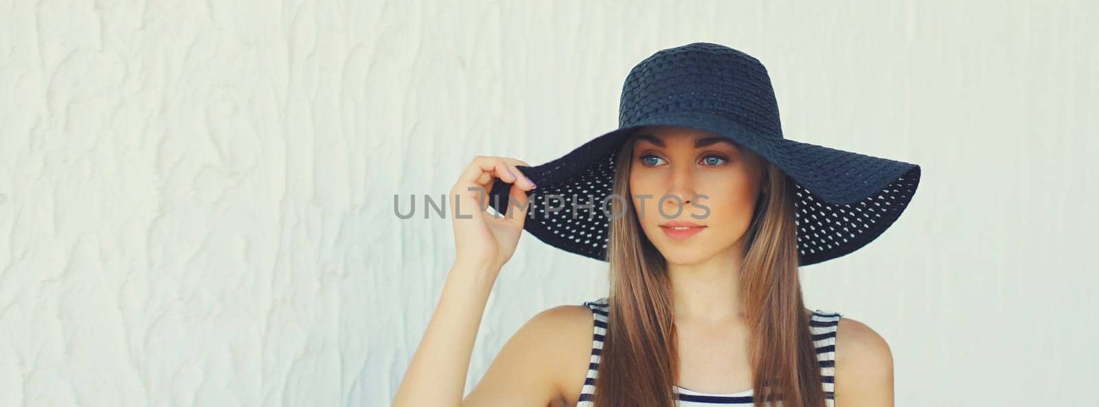 Portrait of beautiful blonde young woman in summer straw hat on white background by Rohappy