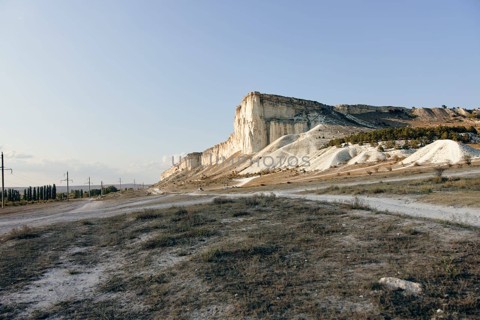 Scenic view of white cliffs with a road and power line stretching into the distance