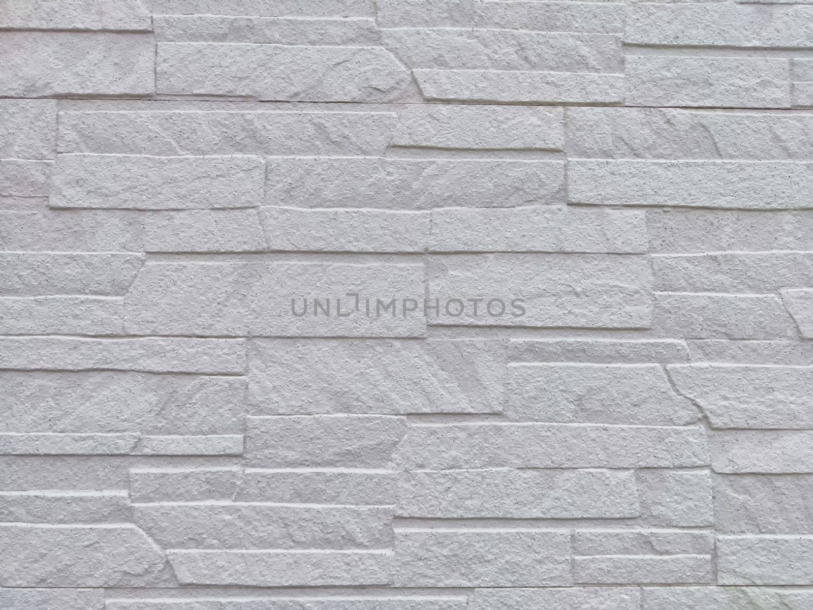 Uneven stones or bricks as background and texture. Background, texture, pattern, frame, copy space. Close-up view of a wall with uneven stone bricks