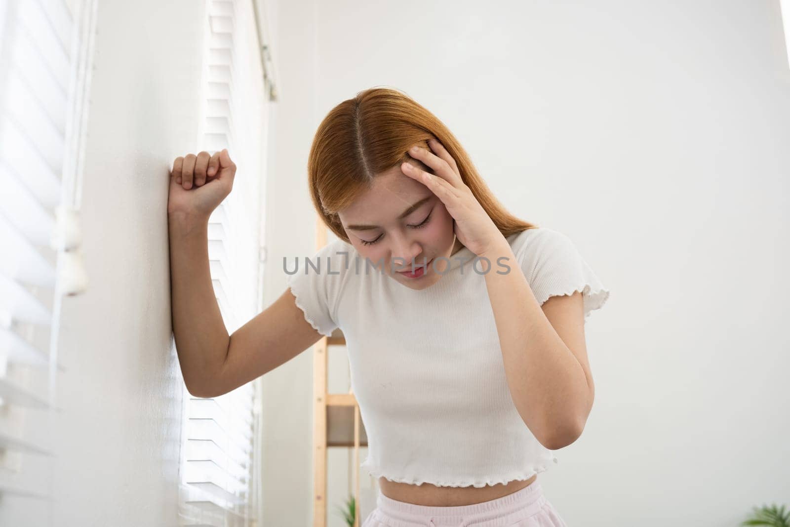 Asian woman feeling headache and stress at home. Concept of mental health, stress, and anxiety.