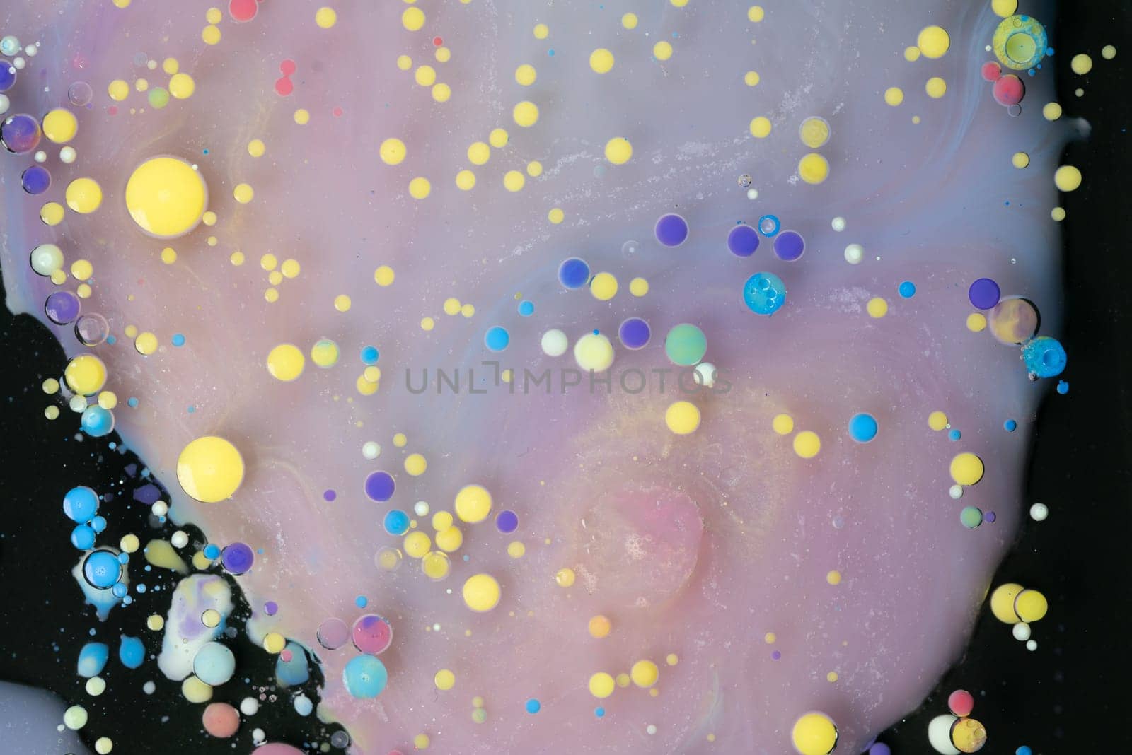 A myriad of oil droplets intermingling with water, creating a mesmerizing effect reminiscent of a galaxy.