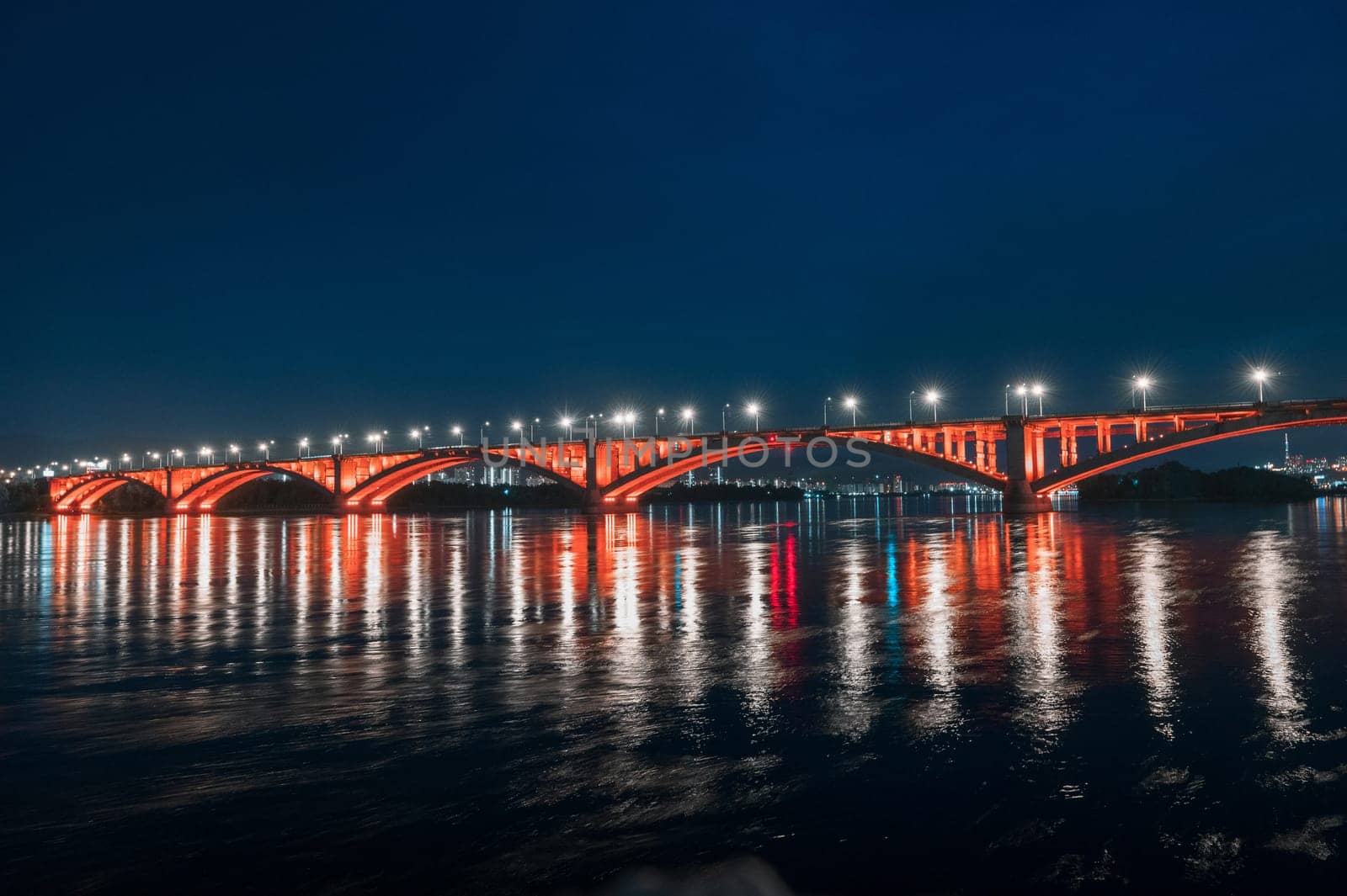 Night view of the famous Communal bridge in Krasnoyarsk through the Yenisei River in Russia, Krasnoyarsk. This bridge is depicted on the 100 rouble bill