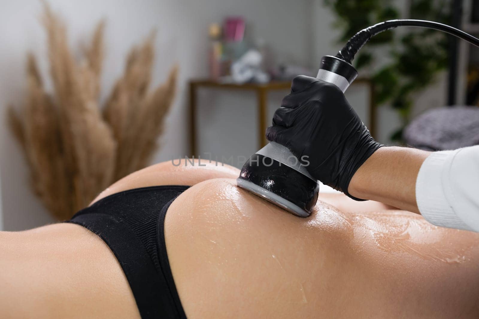 Close up womans buttocks during the procedure of ultrasound cavitation for body contouring at beauty salon