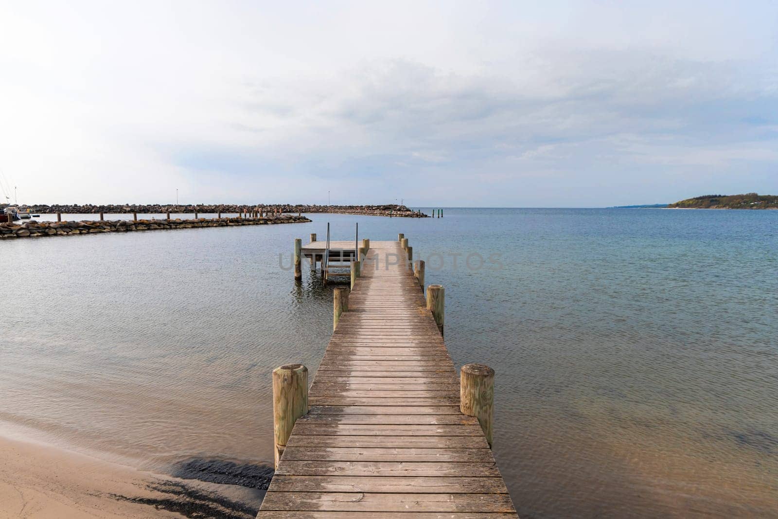 Long wooden pier on the sea. Beautiful landscape view.