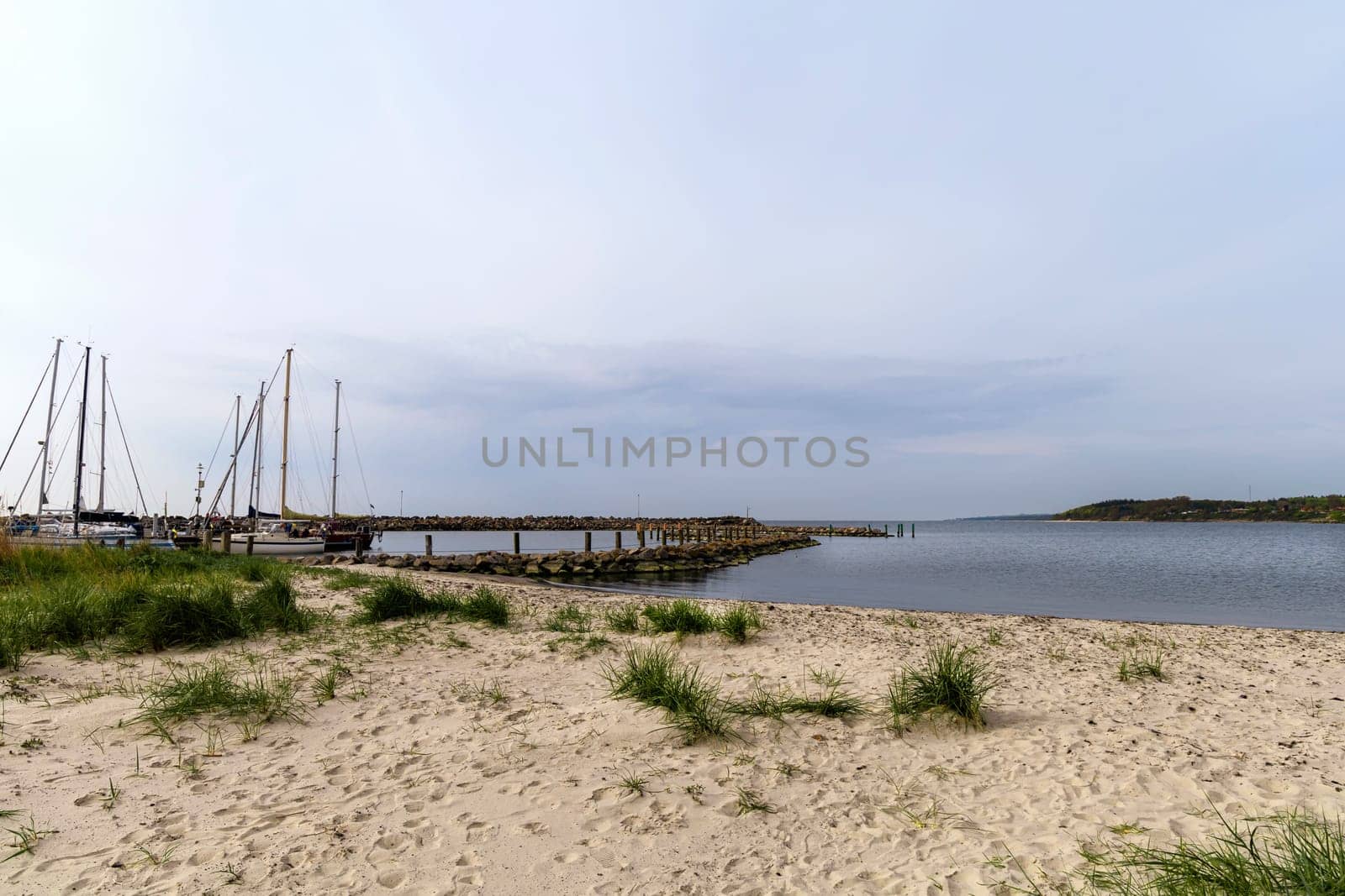 Sea pier with boats and yachts at sunset. Bornholm, Denmark - May 28, 2024. High quality photo