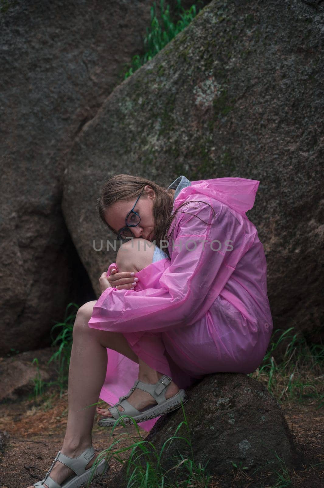 Woman in the raincoat the taiga forest and rocks of the Stolby nature reserve park, Krasnoyarsk, Russia