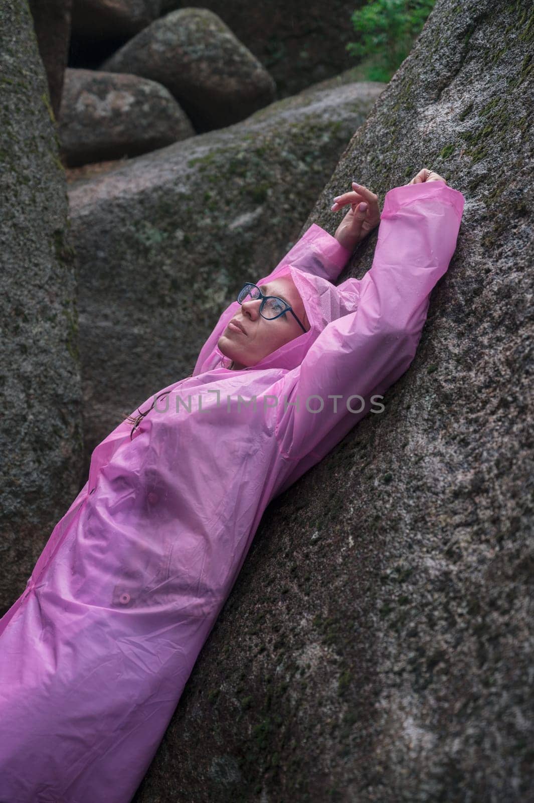 Woman in the raincoat the taiga forest and rocks of the Stolby nature reserve park, Krasnoyarsk, Russia