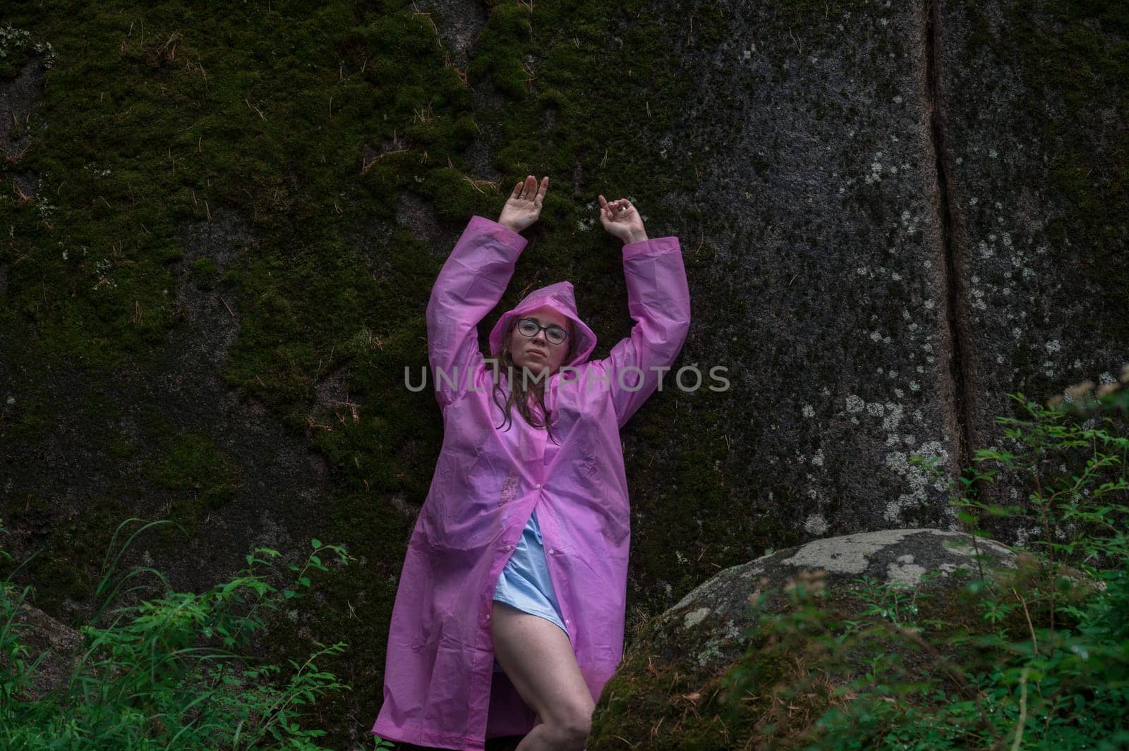 Woman in the raincoat the taiga forest and rocks of the Stolby nature reserve park, Krasnoyarsk, Russia