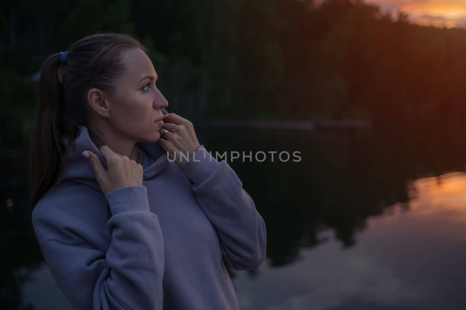 Woman sitting on the pier, closeup portrait, beauty summer sunset