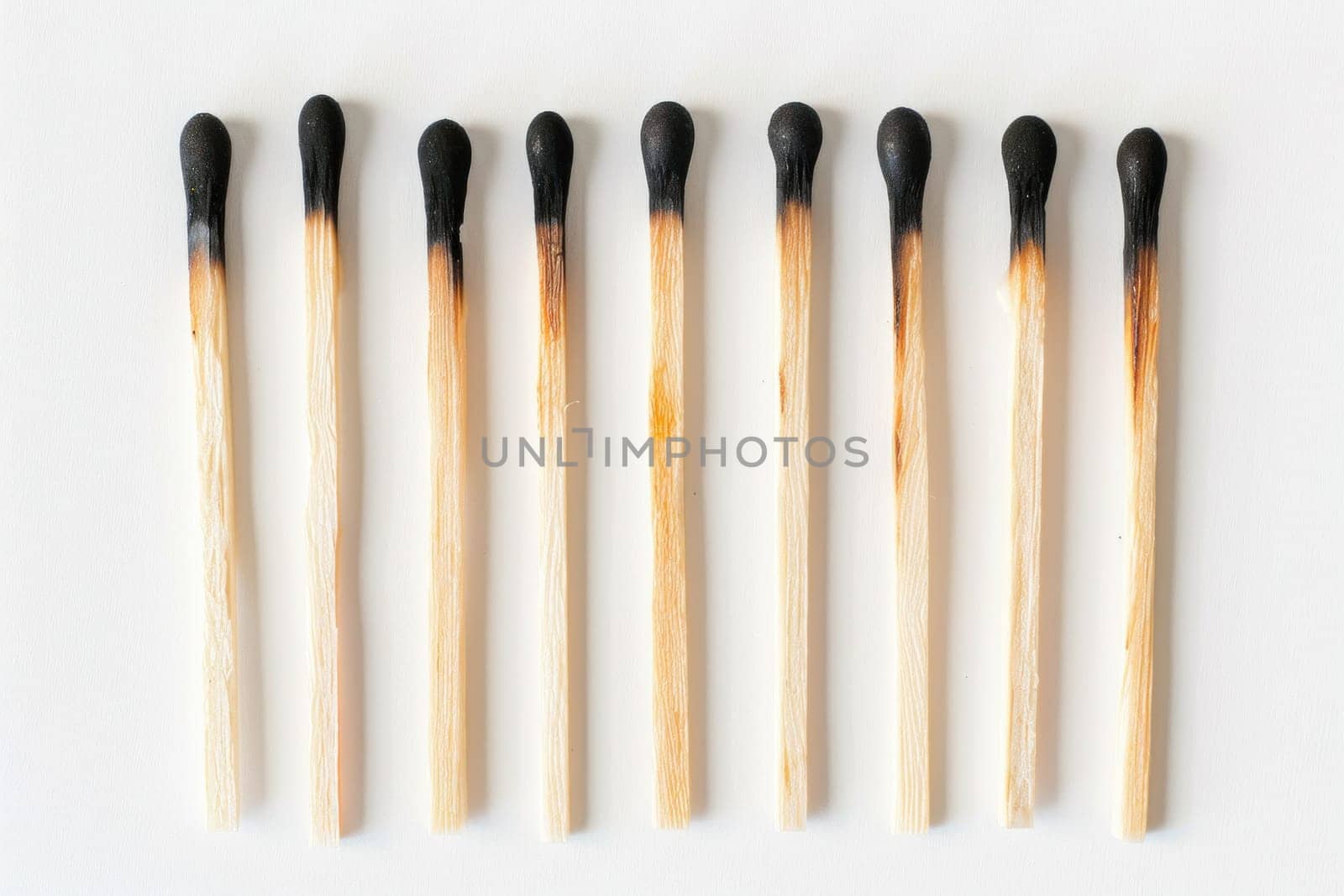 Row of matchsticks on white surface with one black matchstick in the middle creative art concept for business marketing campaign