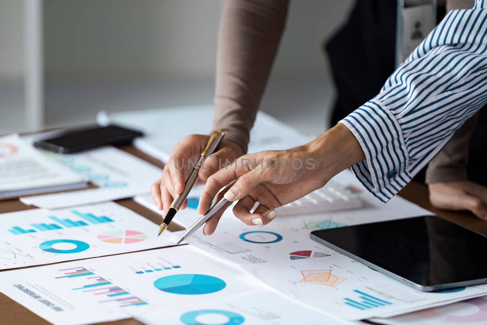 Group of business people meeting together Pointing to the graph assess business profits.