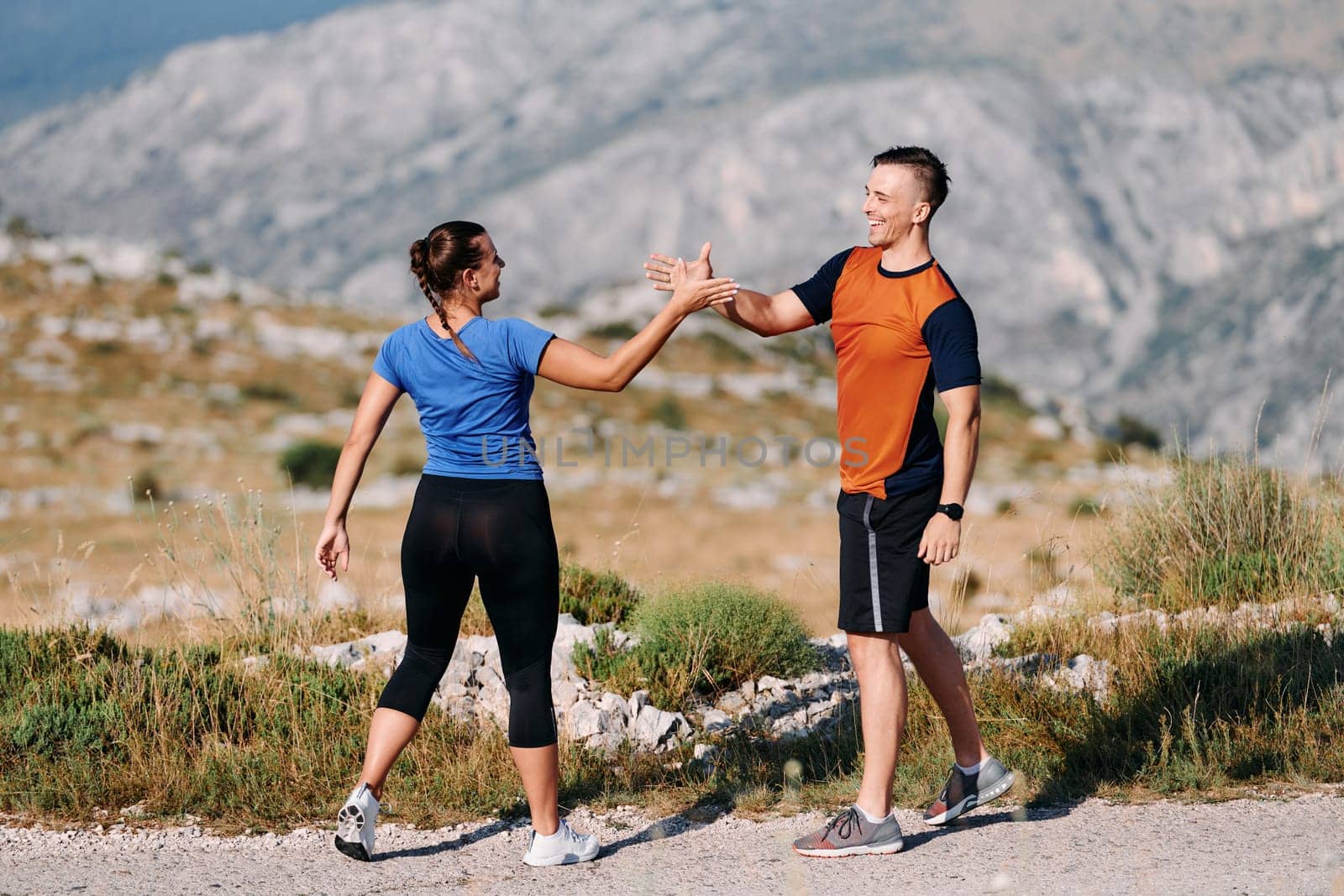 A jubilant couple celebrates their triumphant finish after a challenging morning run, exuding happiness and unity amidst the refreshing outdoor scenery.
