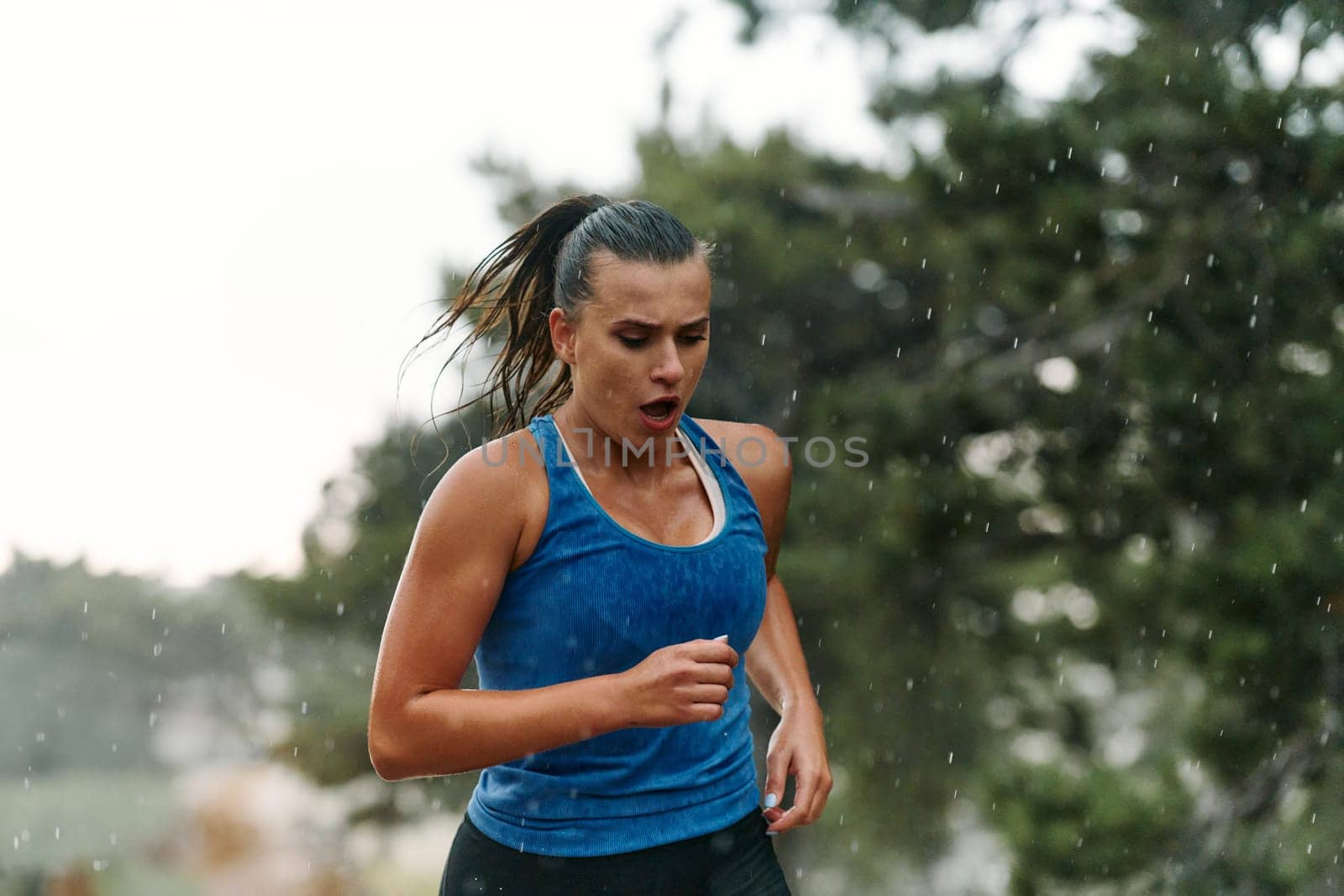 Rain or shine, a dedicated woman powers through her training run, her eyes set on the finish line.