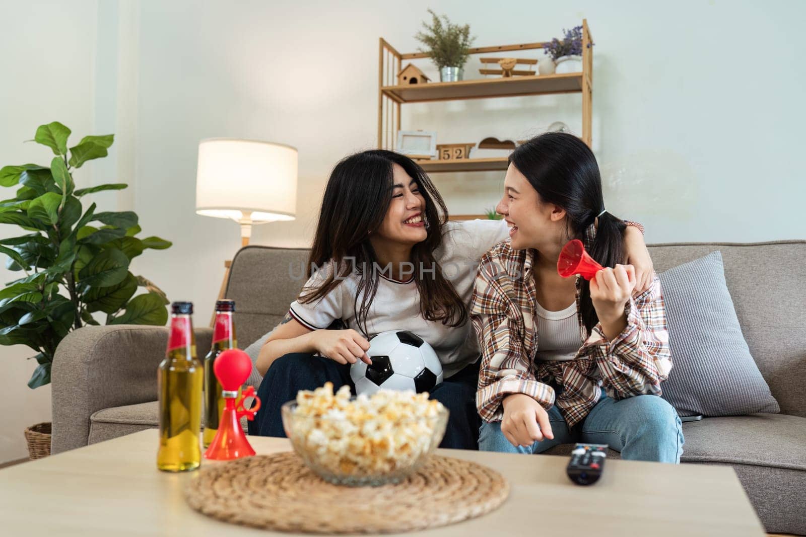 LGBT Soccer or Sport fans emotionally watching game in the living room.