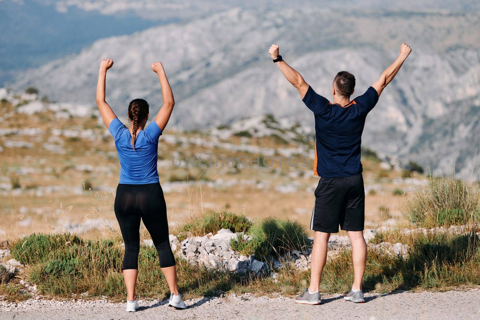 A jubilant couple celebrates their triumphant finish after a challenging morning run, exuding happiness and unity amidst the refreshing outdoor scenery.