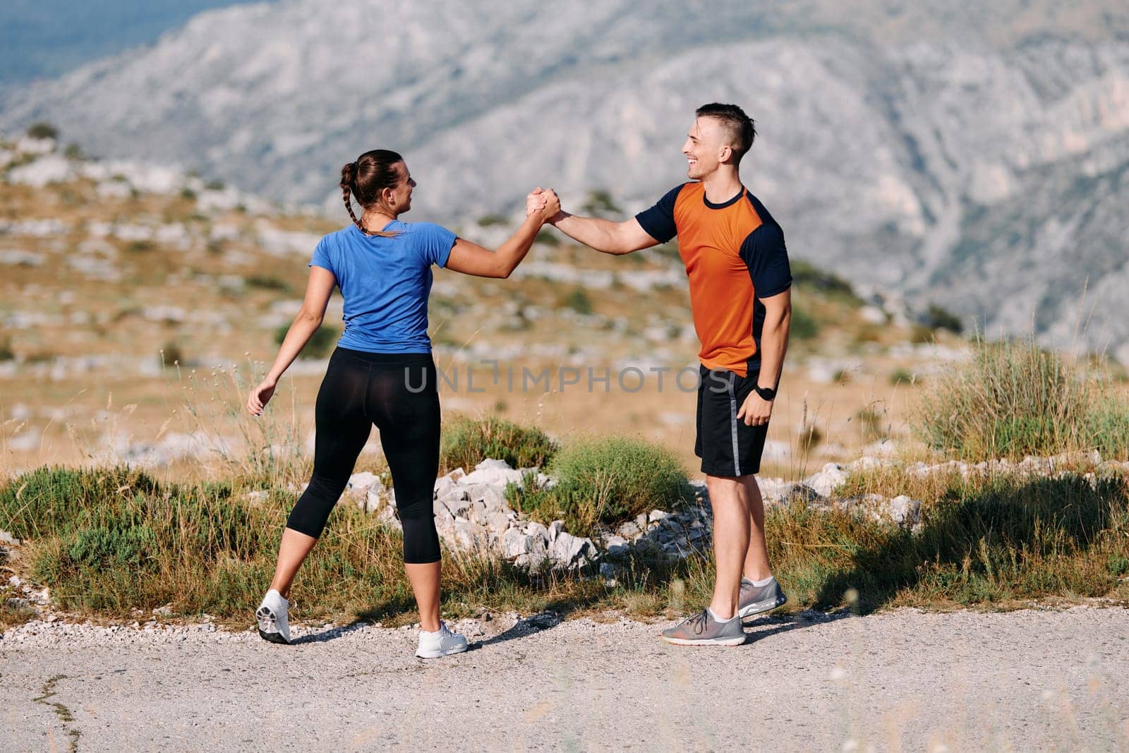 A jubilant couple celebrates their triumphant finish after a challenging morning run, exuding happiness and unity amidst the refreshing outdoor scenery.