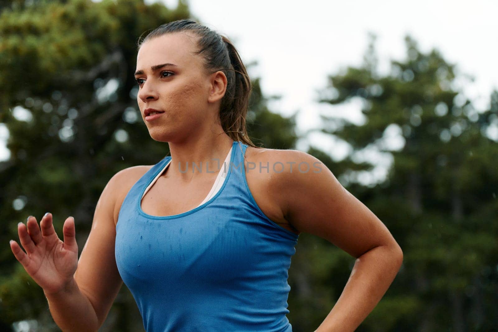 Rain or shine, a dedicated woman powers through her training run, her eyes set on the finish line.