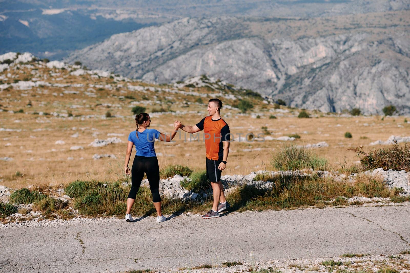 A jubilant couple celebrates their triumphant finish after a challenging morning run, exuding happiness and unity amidst the refreshing outdoor scenery.