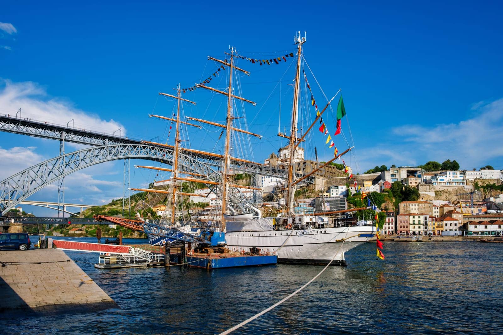 View of Vila Nova de Gaia city with a sailing ship and Dom Luis I bridge over Douro river. Porto, Portugal