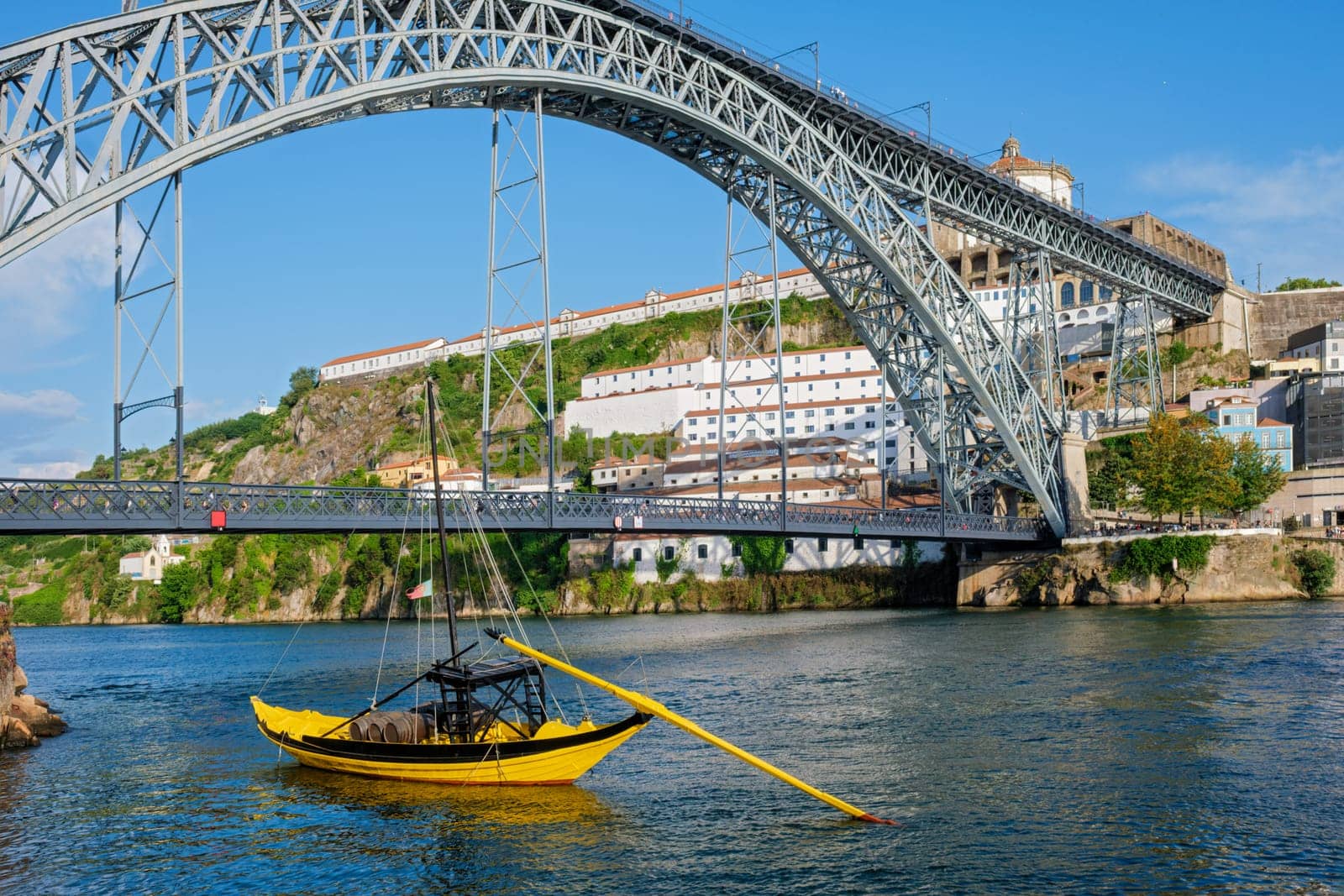 View of Vila Nova de Gaia city with Mosteiro da Serra do Pilar monastery and Dom Luis I bridge over Douro river with traditional boat with port wine barrels. Porto, Vila Nova de Gaia, Portugal